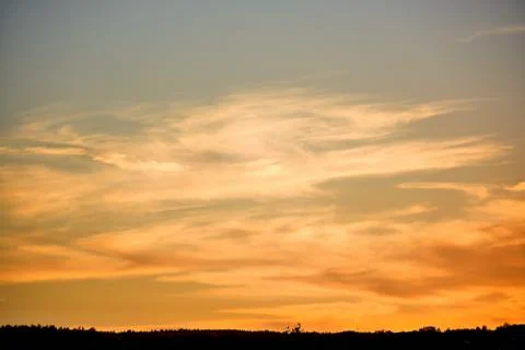 Bright clouds lit by the setting sun which descended in the evening twilight.	 Stock Photos