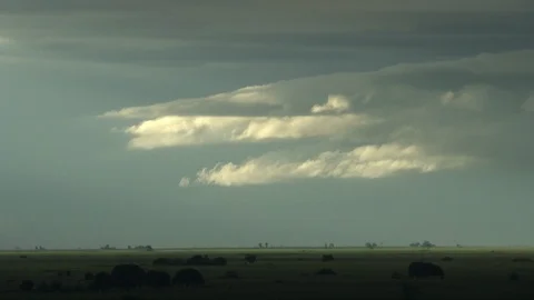 Bright clouds reflecting light above green fields Video stock 98041066