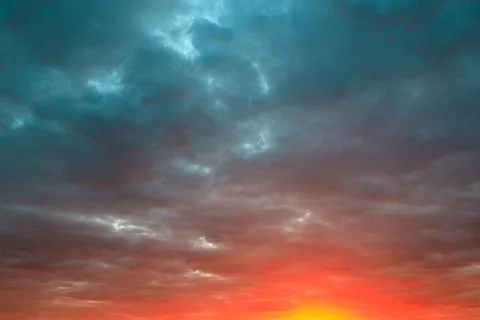 Bright cloudy sky during sunset and sun at the bottom of the frame Foto stock