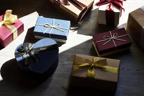  bright collection of wrapped gift boxes with satin and glitter ribbons on a dar Stock Photos