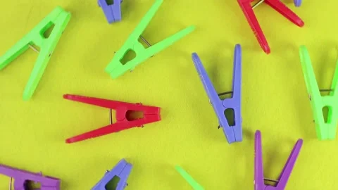 Bright colored clothespins pattern rotate on a yellow background on a turntable, Stock Footage 171244313