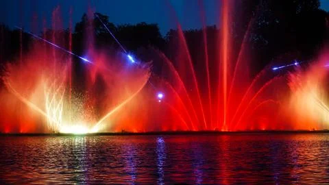 Bright colored light show of fountains in the evening on the river Stock Photos