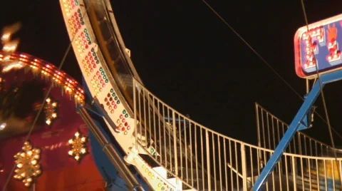 Bright colored lights decorate traveling carnival rides Stock Footage