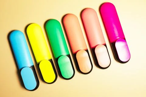 Bright colored markers for highlighting text on beige background, colored Photos