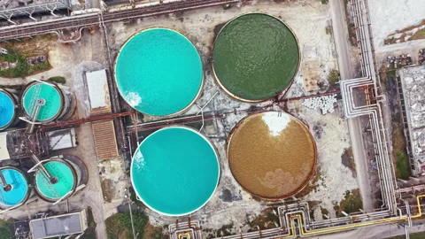 Bright colored tanks sit at a factory near a road showing different colors of Stock Footage 341383651