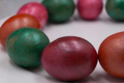 Bright colorful Easter eggs on red plate on pink background. Stock Photos