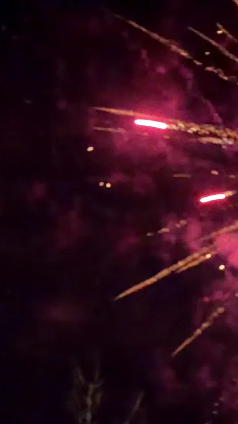 Bright colorful fireworks exploding in the dark night sky, creating vibrant Stock Footage 345832169