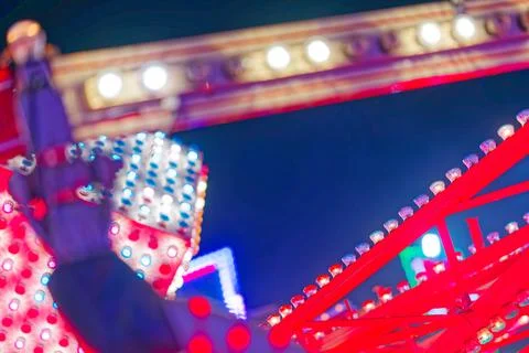 Bright colorful lights and structures at a night carnival or amusement park Stock Photos