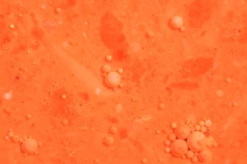 Bright colorful orange bubbles on the surface of the water. Abstract paint bu Illustrazione stock