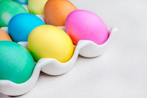 Bright colorful painted Easter eggs lying on white table. Traditional decor.. Stock Photos