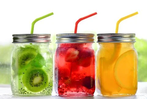 Bright Colorful refreshing summer drinks in glass jars with lid and straws on a Stock Photos
