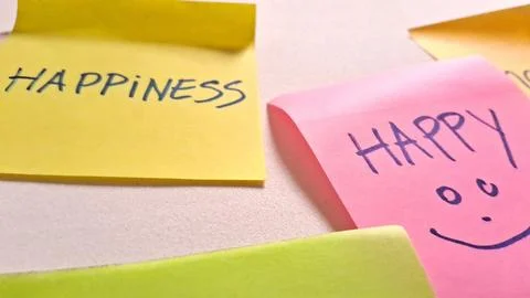 Bright colorful sticky notes featuring hand written words about feeling happy Stock Photos