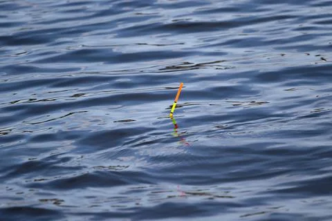 Bright colorful thin float on blue water with small smooth waves which Foto stock