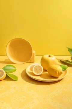 Bright composition of ceramic plate with lemon and apple Stock Photos