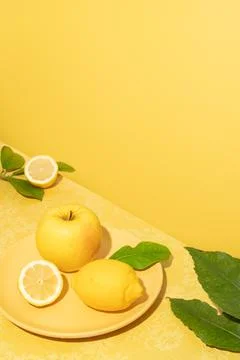 Bright composition of ceramic plate with lemon and apple Stock Photos