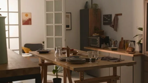 Bright Cozy Kitchen and Dining Area with Wooden Table Set for Meal Stock Footage 303045695
