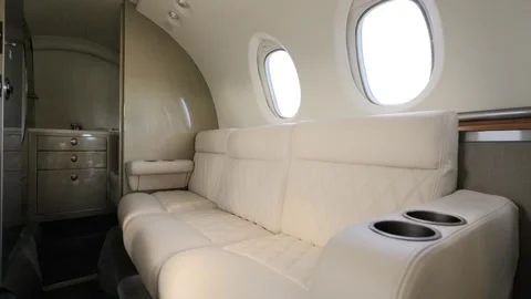 Bright cozy leather couch in front section of business airplane near area for Stock Footage 249603139