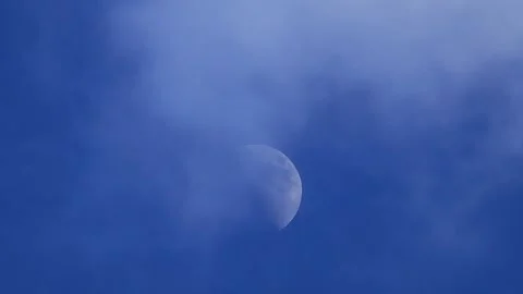 Bright crescent moon over clear blue sky during daytime Stock Footage 296113701