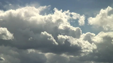 Bright cumulus clouds barrelling across the sky Stock Footage