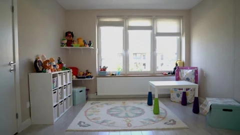 Bright daylight gradually illuminates a tidy and organized children's playroom 스톡 동영상 335786243