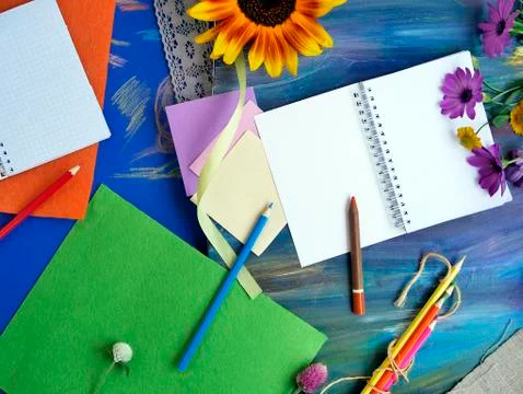 Bright decorative composition of art materials, notepad and flowers Stock Photos