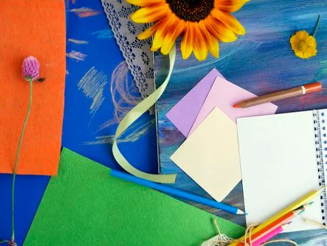 Bright decorative composition of art materials, notepad and flowers Stock Photos
