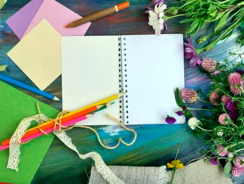 Bright decorative composition of art materials, notepad and flowers Stock Photos