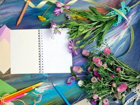 Bright decorative composition of art materials, notepad and flowers Stock Photos