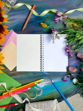 Bright decorative composition of art materials, notepad and flowers Stock Photos
