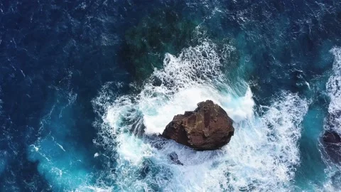 Bright deep blue waves crashing on a large sea stack at spitting cave Stock Footage 234584056