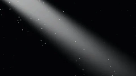 A bright diagonal spotlight beam emerging from darkness with floating particles 库存影片 335118144