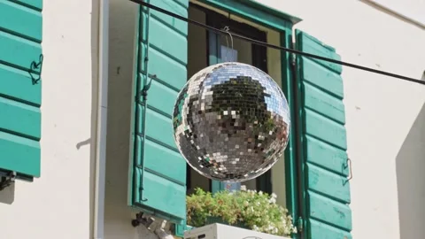 A bright disco ball of their square mirror pieces hangs on a rope in the Stock Footage 212419311