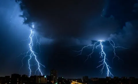 Bright double flash of powerful lightning in the city at nighttime. Stock Photos