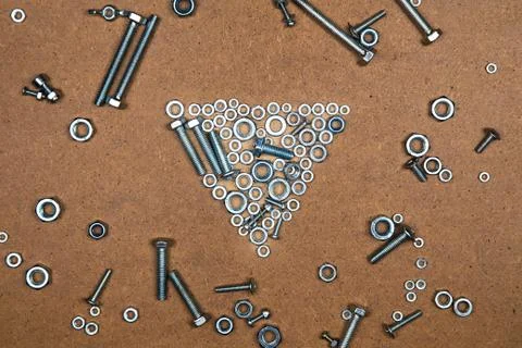 Bright down triangle from bolts and nuts Stock Photos
