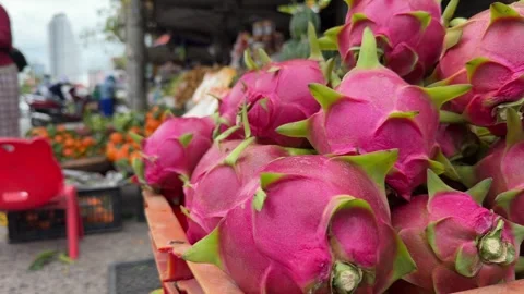 Bright dragon fruit is arranged in crates for sale, with assorted fruits and 動画素材 329298431