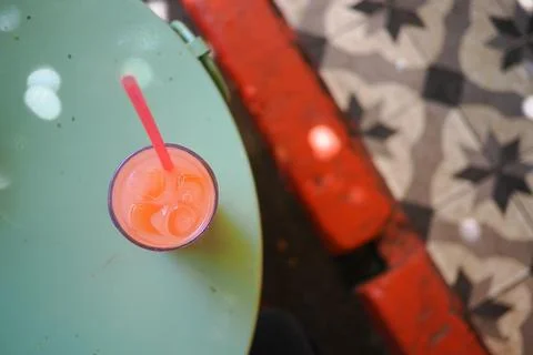Bright drink on a green table with patterned floor Stock Photos