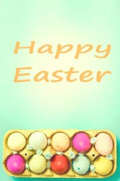 Bright Easter eggs lie in a box on a blue background Stock Photos