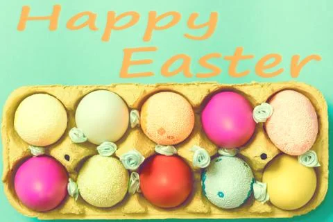 Bright Easter eggs lie in a box on a blue background Foto stock