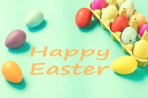 Bright Easter eggs lie in a box on a blue background Stock Photos