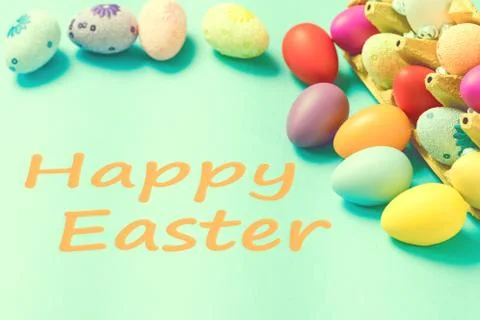 Bright Easter eggs lie in a box on a blue background Stock Photos