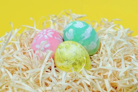 Bright Easter eggs in the nest on a yellow background. Selective focus. Easter Stock Photos