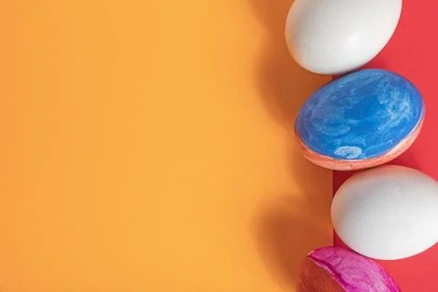 Bright Easter eggs on an orange and red background. Stock Photos
