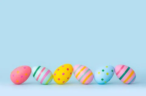 Bright Easter eggs in a row on a blue background Stock Photos