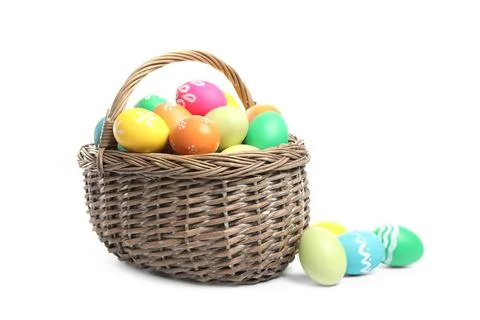 Bright Easter eggs in wicker basket isolated on white background 写真素材