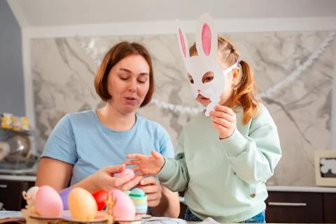 A bright Easter preparation scene with a young mother and her daughter wear.. Stock-Fotos
