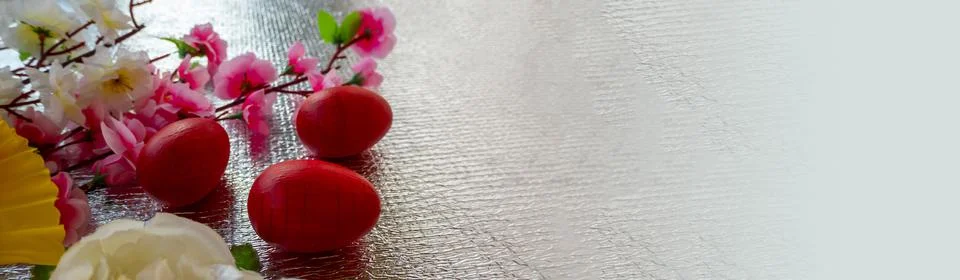 Bright Easter silver background decorated with ribbons of flowers and red egg Stock Photos