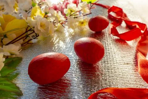 Bright Easter silver background decorated with ribbons of flowers and red egg Stock Photos