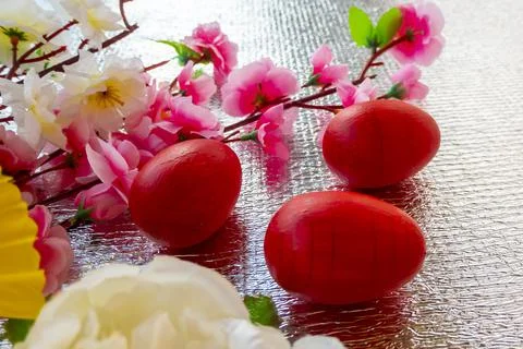 Bright Easter silver background decorated with ribbons of flowers and red egg 스톡 사진