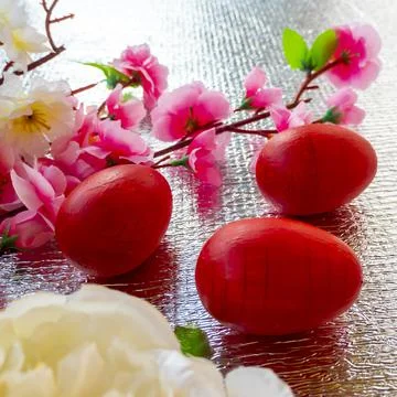 Bright Easter silver background decorated with ribbons of flowers and red egg Stock Photos