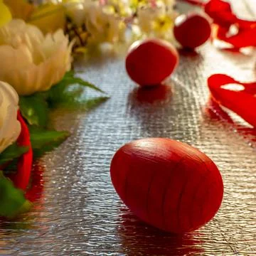 Bright Easter silver background decorated with ribbons of flowers and red egg Stock Photos